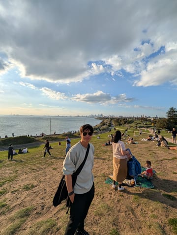 Sean on a hillside overlooking a bay